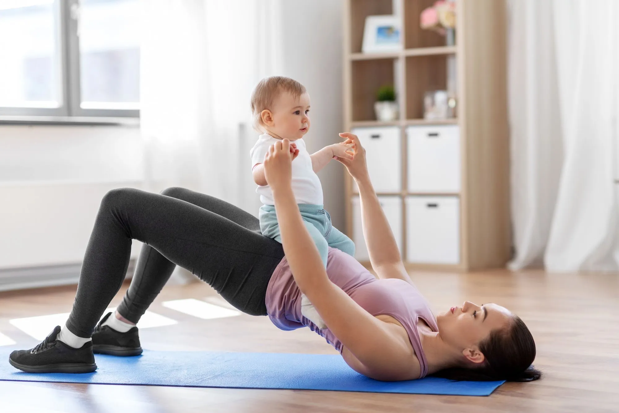 Foto-Brief: dokumentarisch, eine Frau einige Wochen nach der Geburt sitzt ruhig und aufrecht auf einer Matte zu Hause, Baby in der Nähe, Tageslicht — warm, alltagsnah, entspannt, kein angestrengtes Übungs-Posing. Keyword: Beckenbodentraining nach der Geburt.